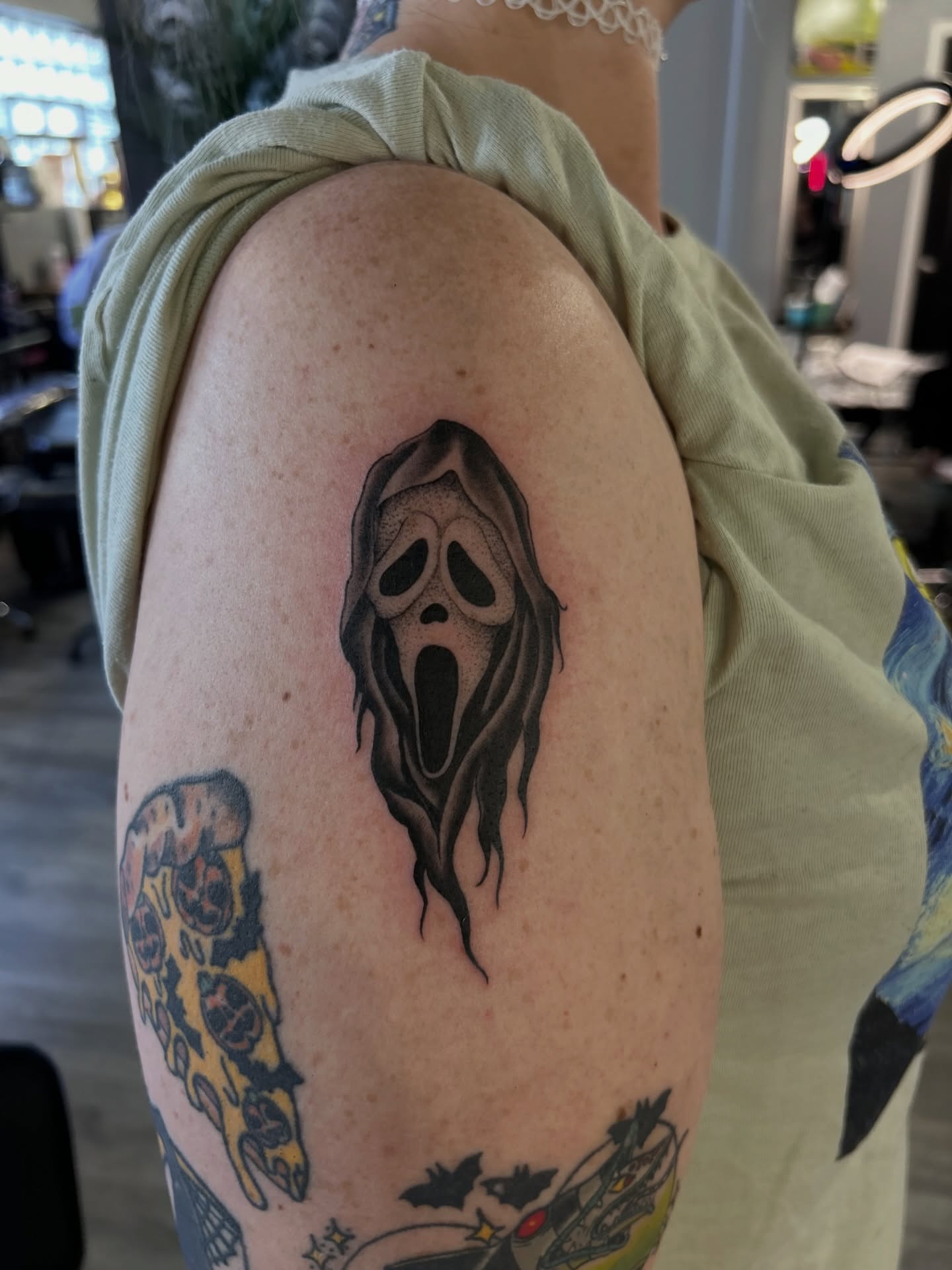 Ghost mask black and grey tattoo on the upper arm by Oto_art