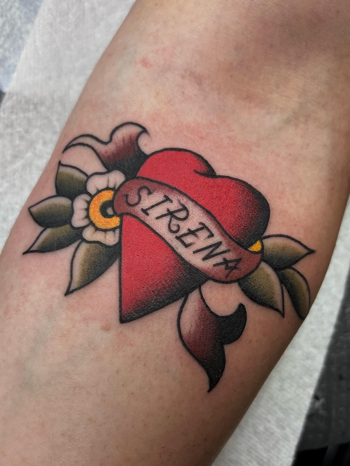 Flower and ribbon American traditional tattoo on the forearm by Jade McKenzie, Temecula, California
