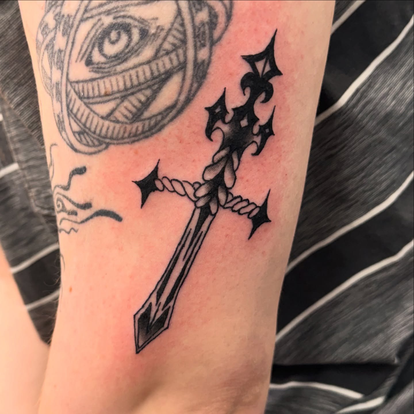 Cross black and grey tattoo on the forearm by Gabe Rosen
