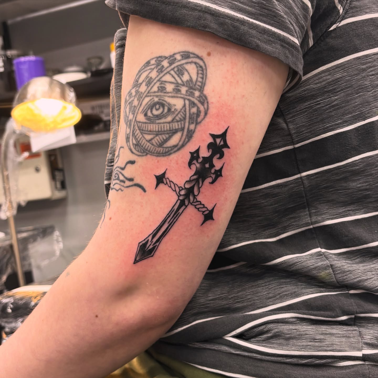 Eye and cross black and grey tattoo on the forearm by Gabe Rosen