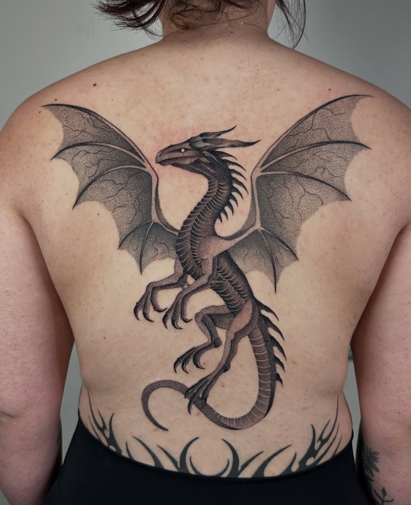Dragon black and grey tattoo on the back by Brooklyn Bailey