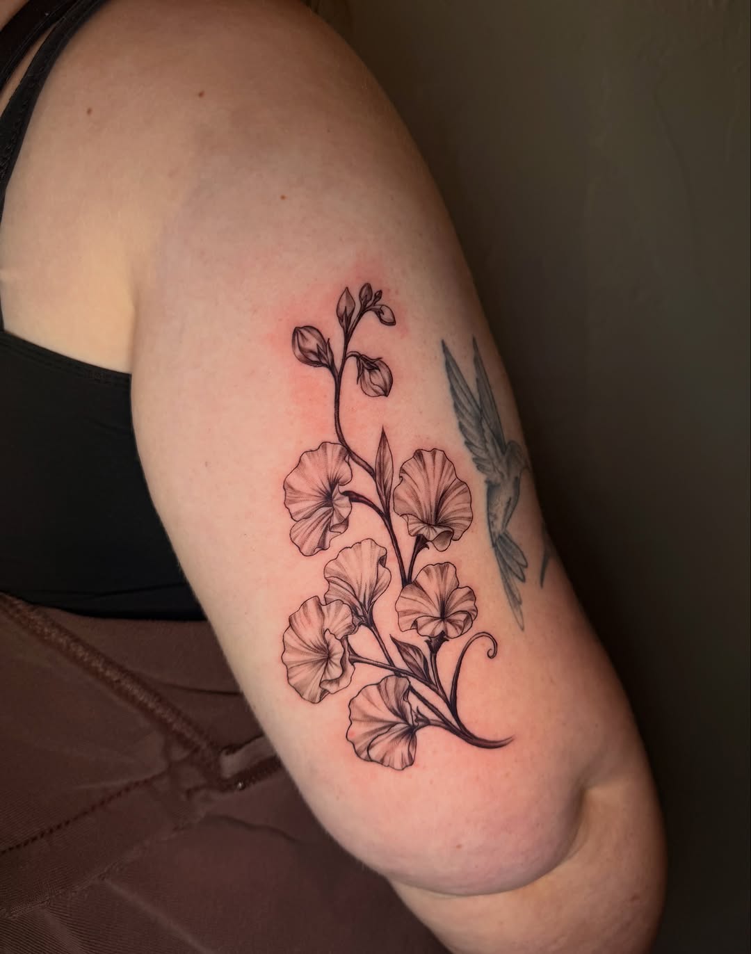 Sweet pea flowers fine line tattoo on the upper arm by jayla pantig