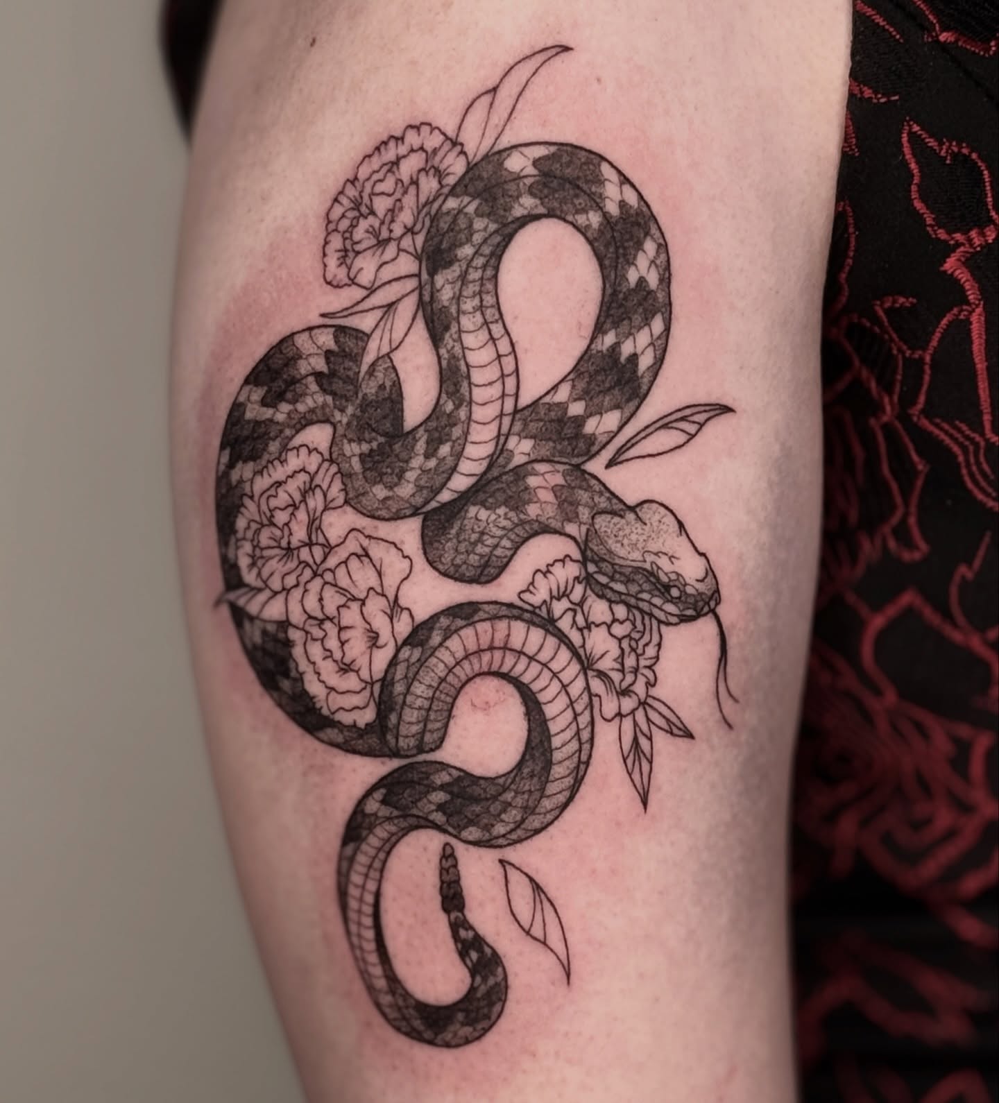 Snake and peony realism tattoo on the forearm by Jordan