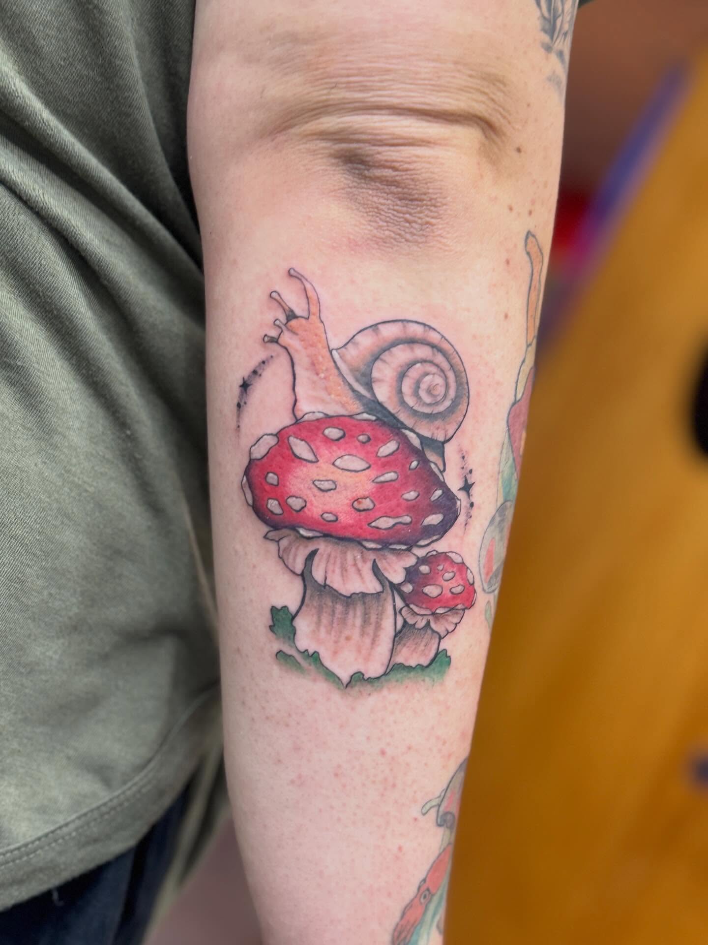 Snail and mushroom realism tattoo on the forearm by Rebecca Rose