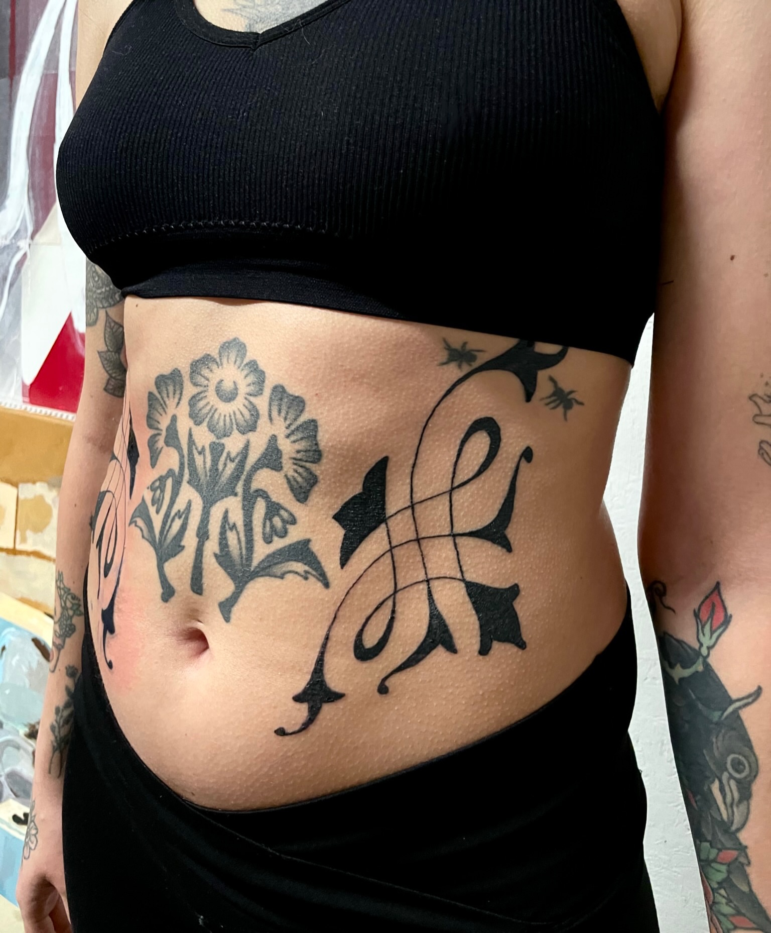 Floral and script ornamental tattoo on the torso by bisabuelita