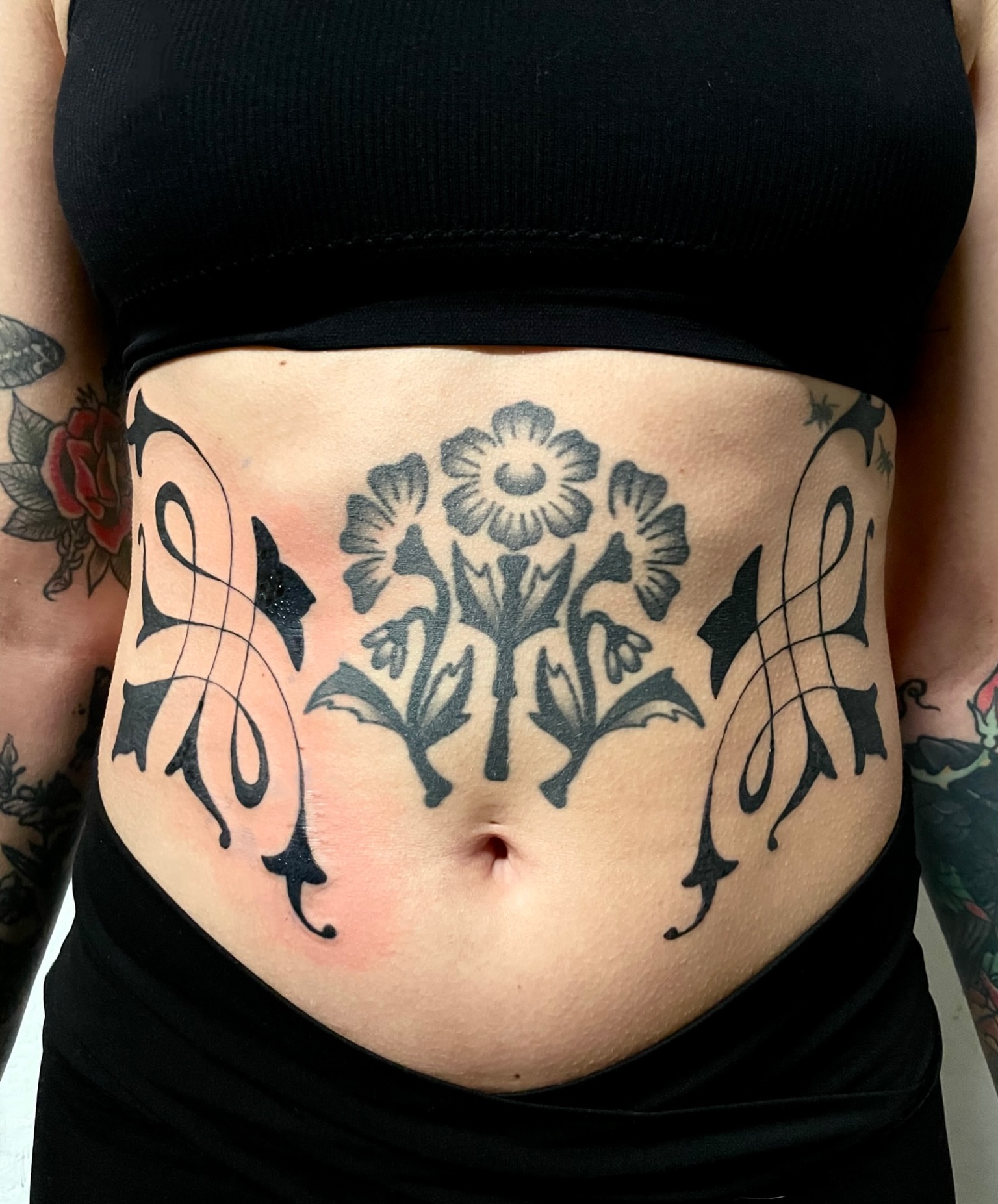 Floral design black and grey tattoo on the torso by bisabuelita