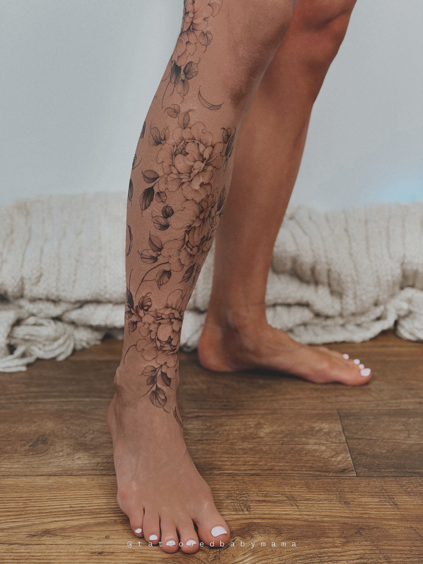 Floral bouquet black and grey tattoo on the calf by Andrea Evangelista