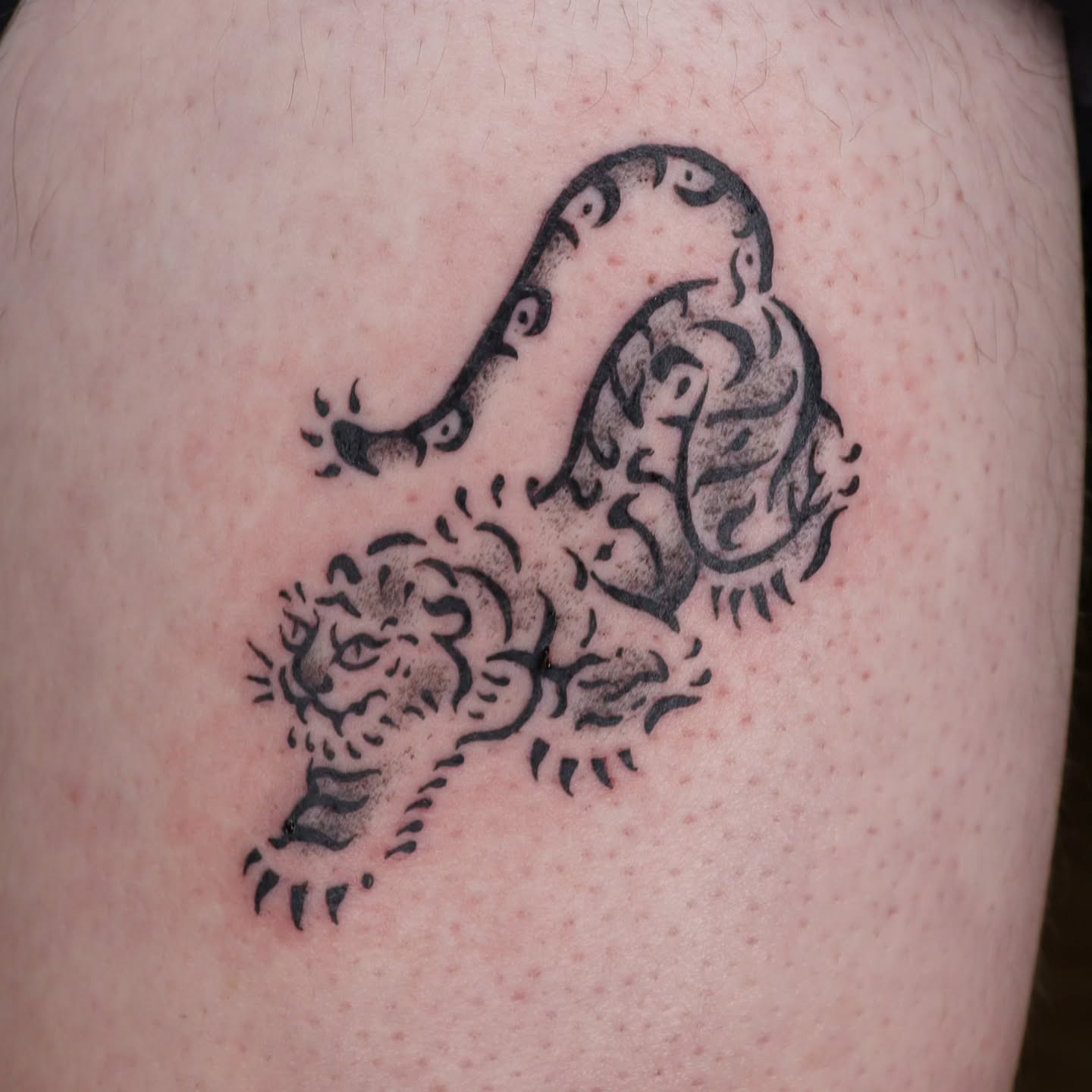 Tiger black and grey tattoo on the thigh by Veronika Lipchak