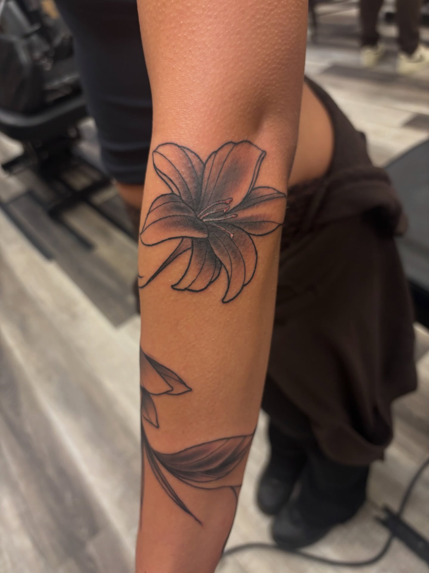 Lily black and grey tattoo on the forearm by Megan