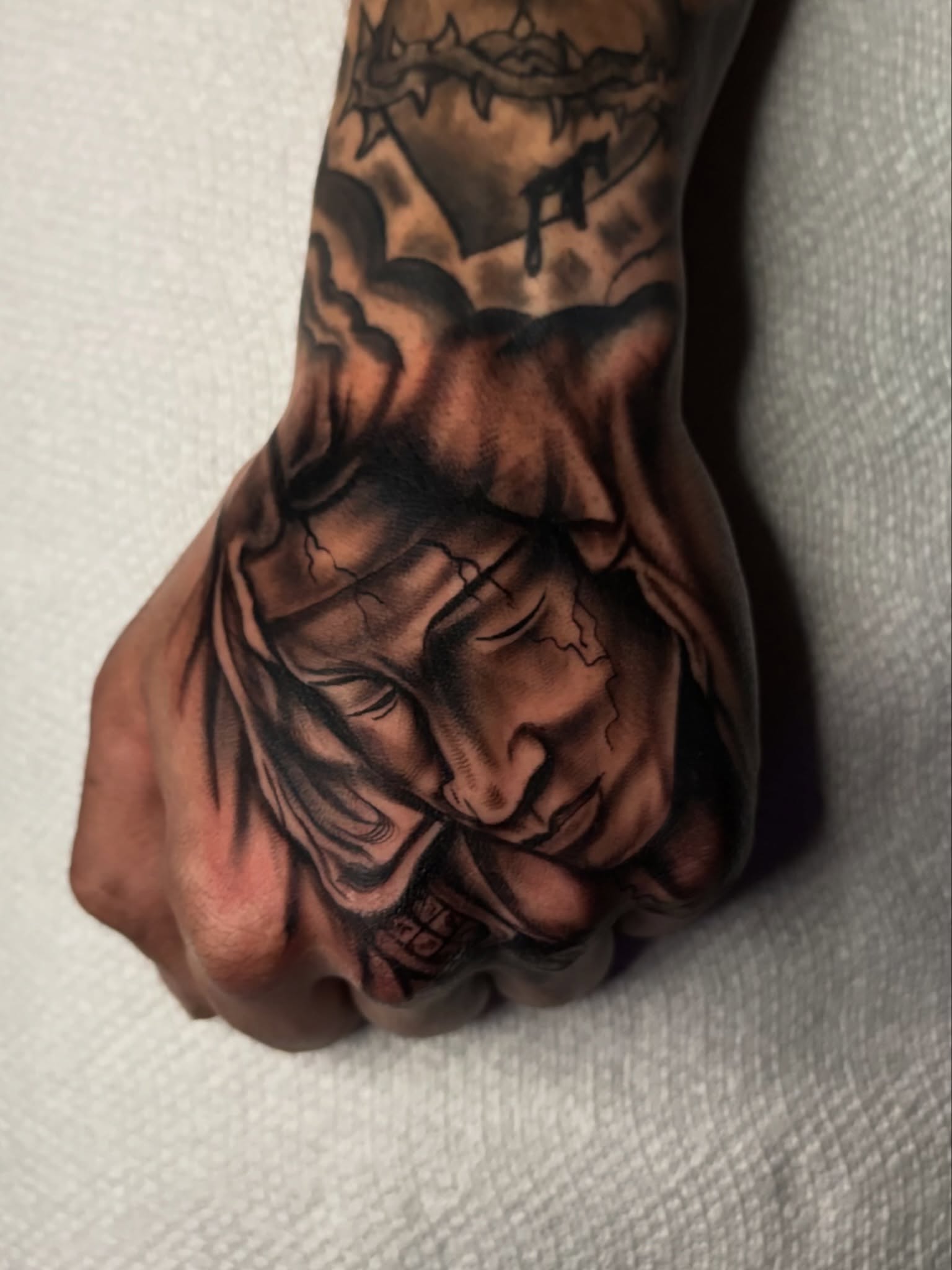 Jesus Christ realism tattoo on the hand by Messias Tattoo Artist