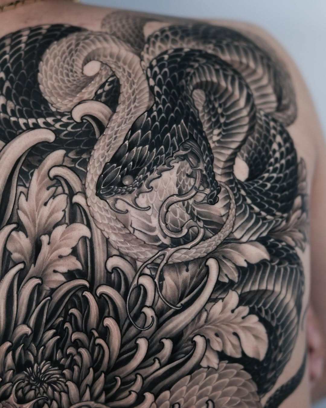 Snake and chrysanthemum Japanese tattoo on the back by Yujin Ju