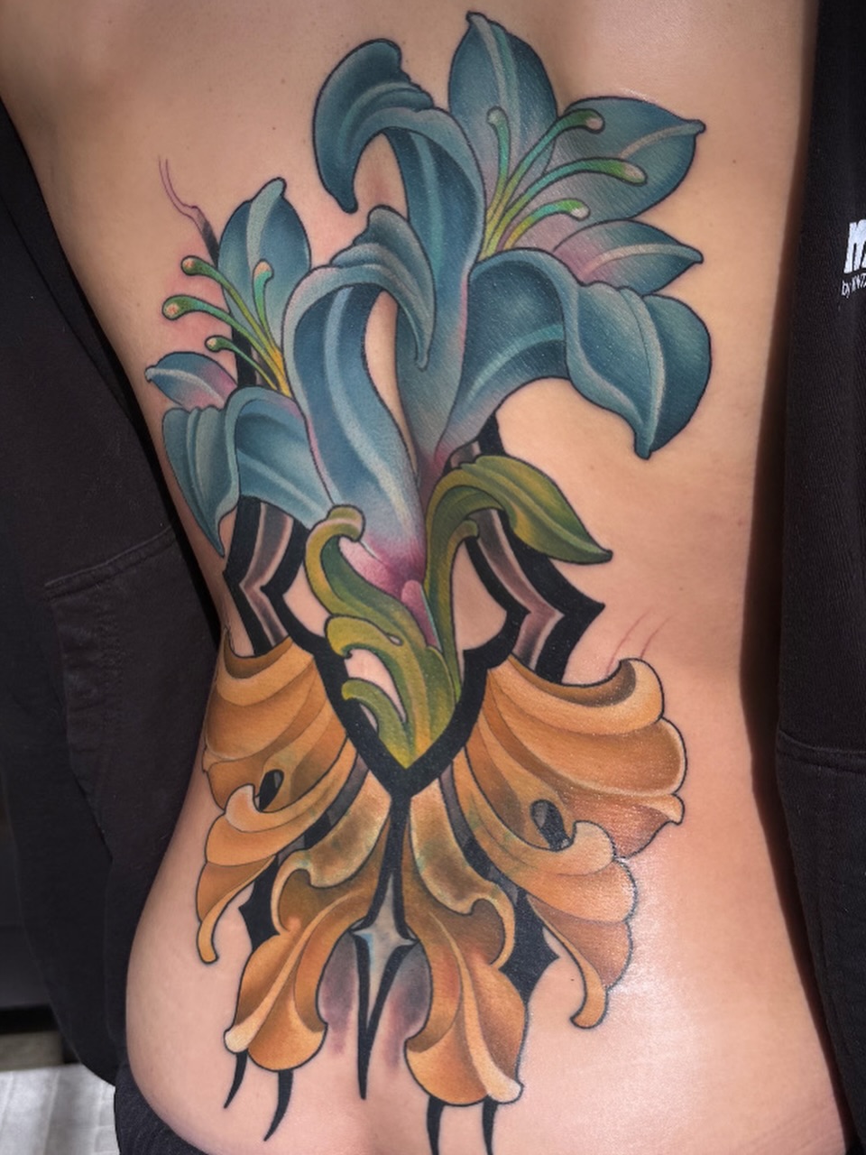 Lilies American traditional tattoo on the ribs by Melis Fusco