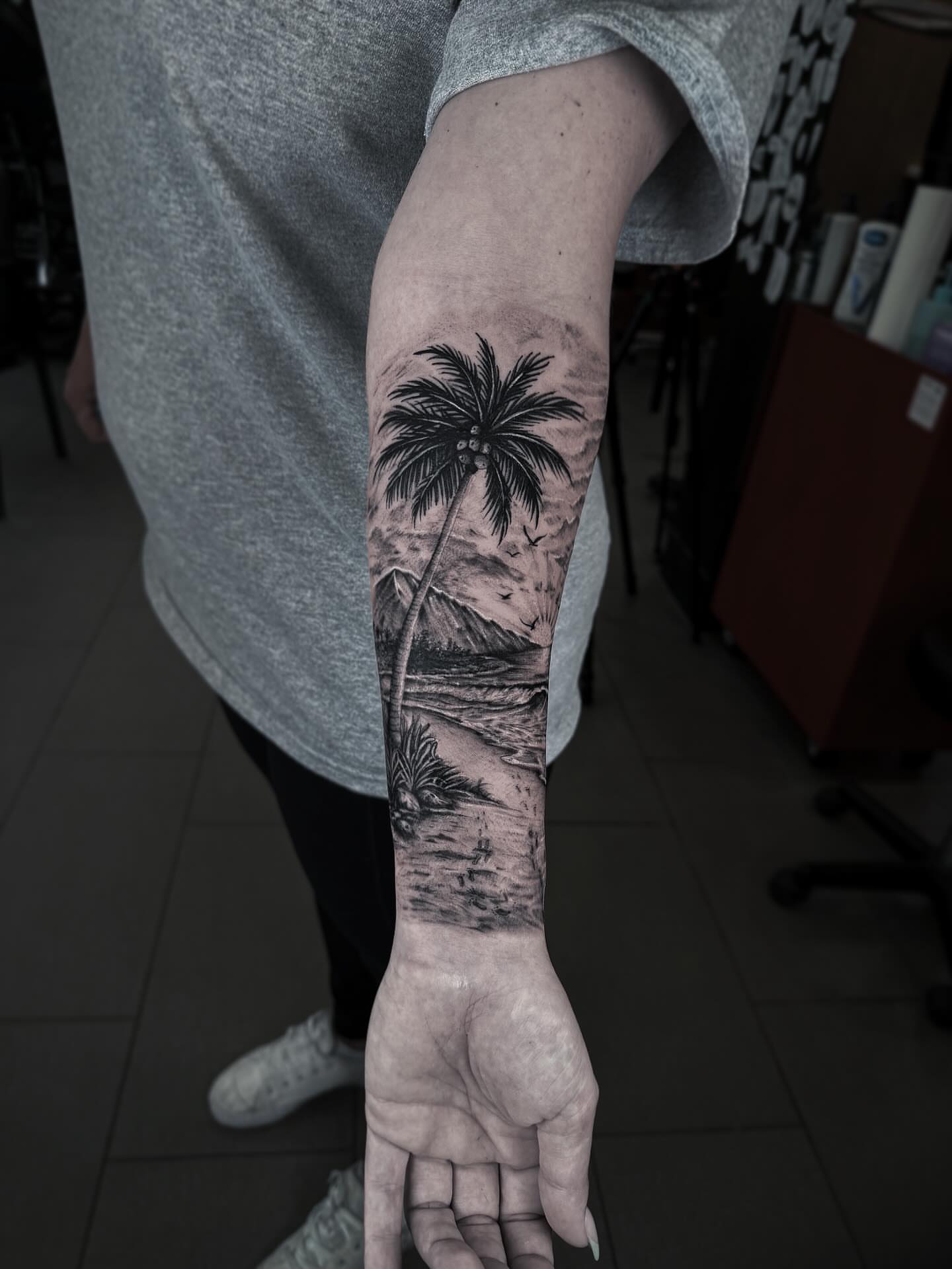 Beach scene realism tattoo on the forearm by Tattoo Ottawa