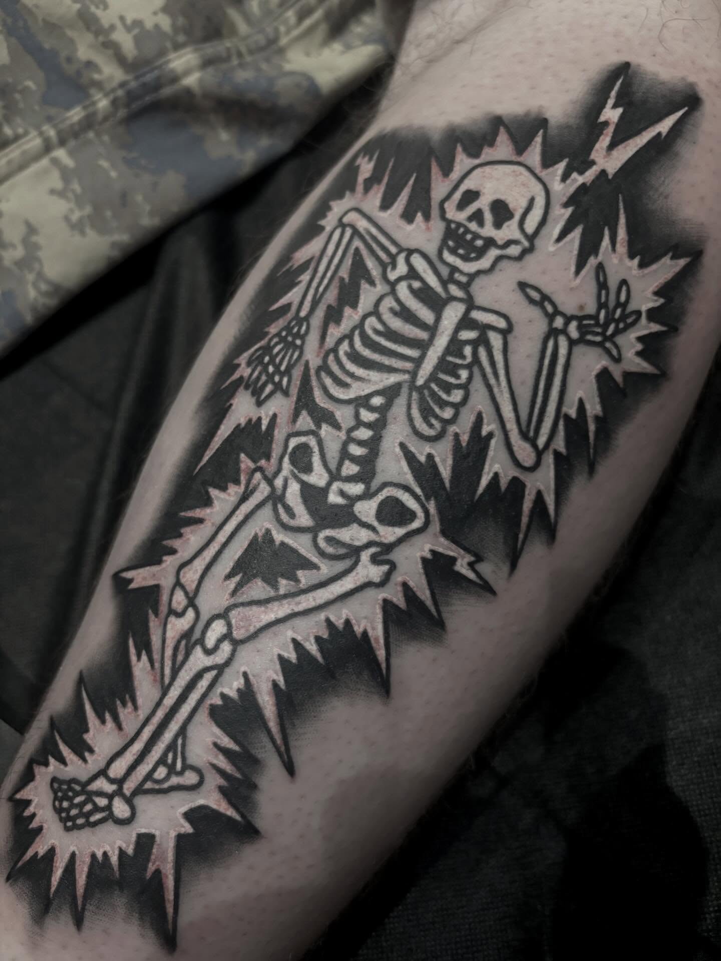 Skeleton with lightning bolt American traditional tattoo on the forearm by Alex Green, Nashville, Tennessee