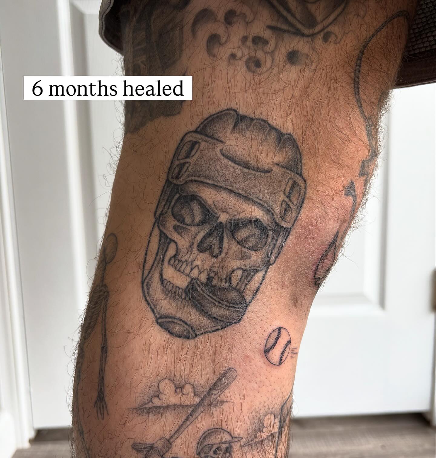Skull wearing helmet black and grey tattoo on the forearm by Hailey Nicole