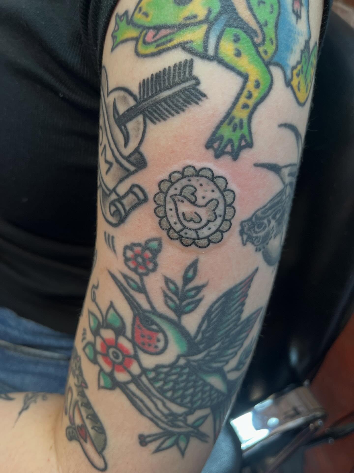 Bird and floral American traditional tattoo on the forearm by Evan Voelker