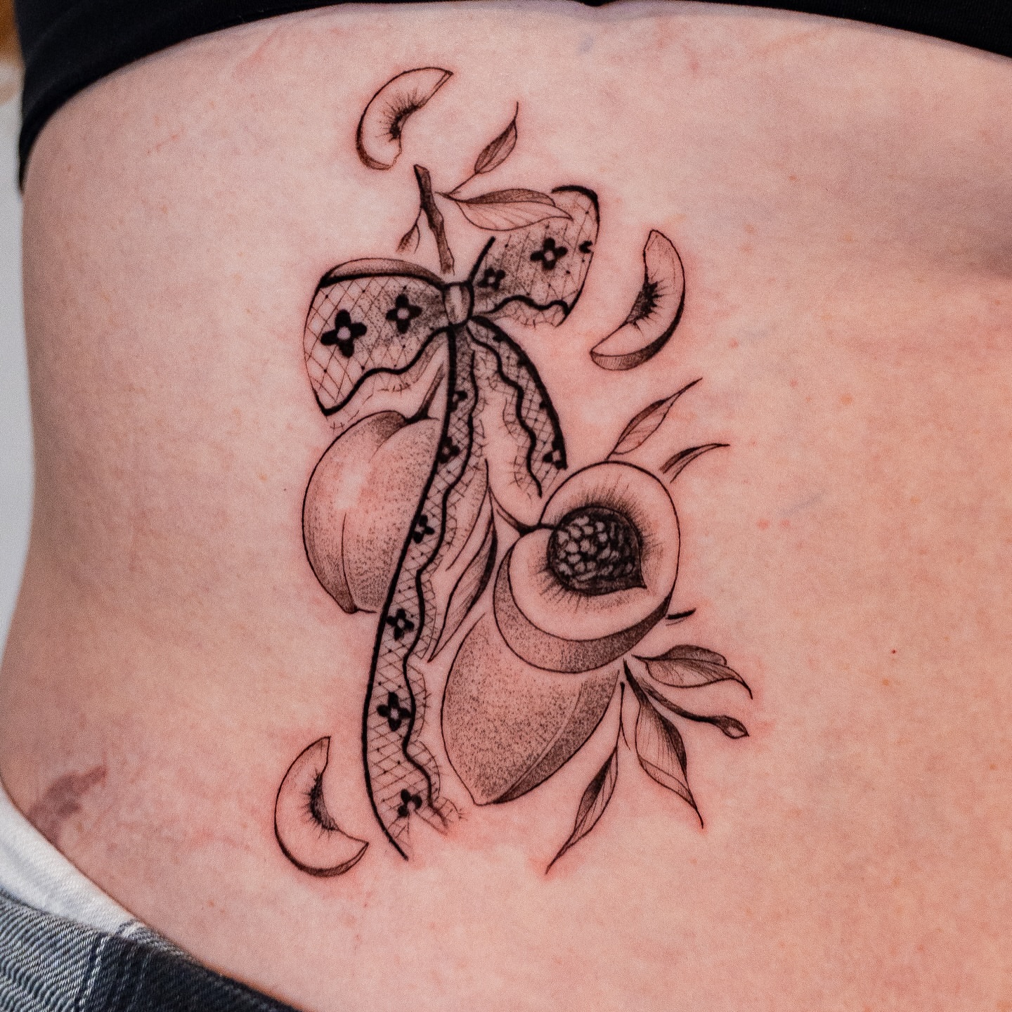 Peach and butterfly black and grey tattoo on the torso by Kalin, Seattle, Washington