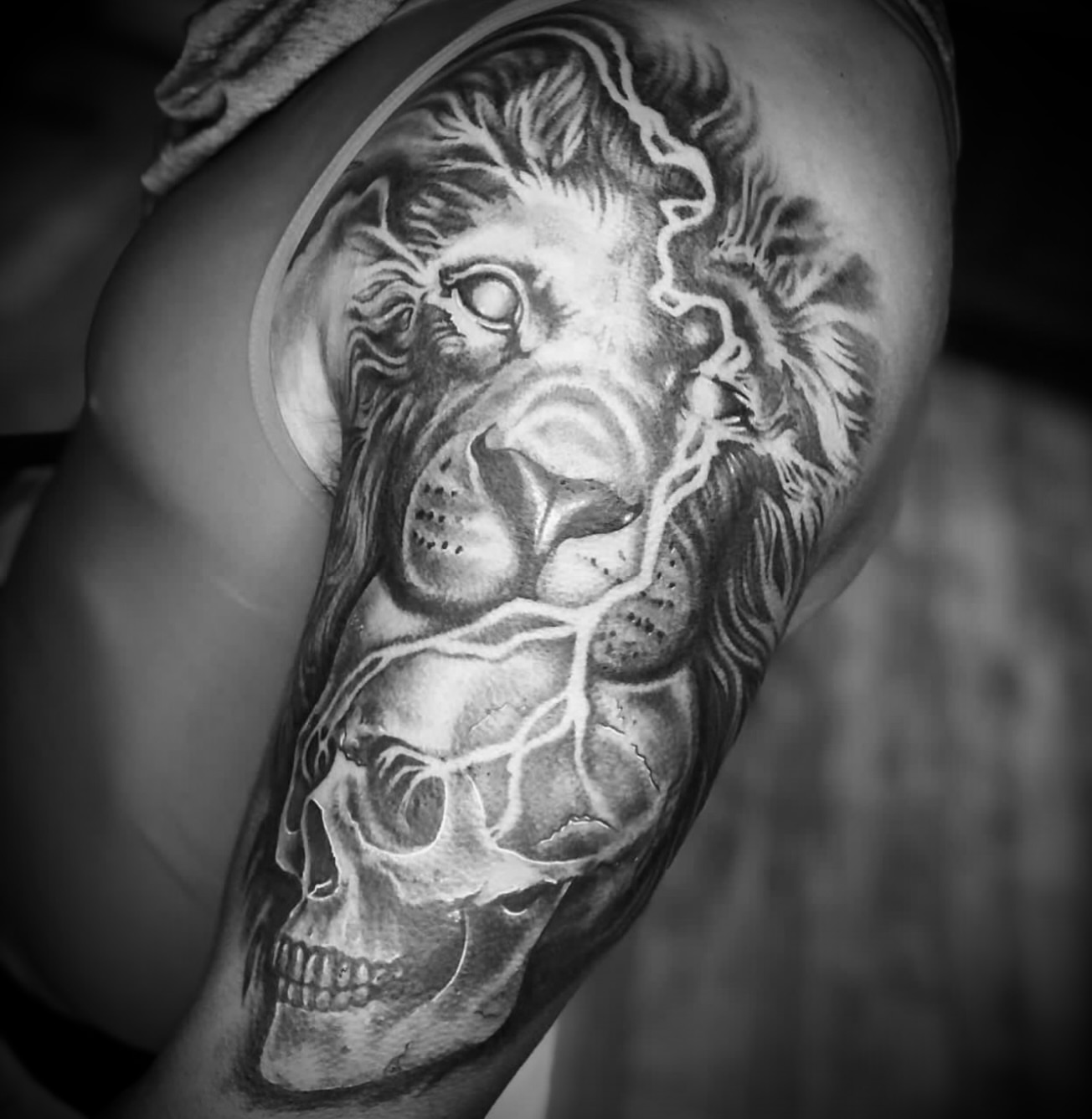 Lion and skull realism tattoo on the shoulder by Big Steve Lewis