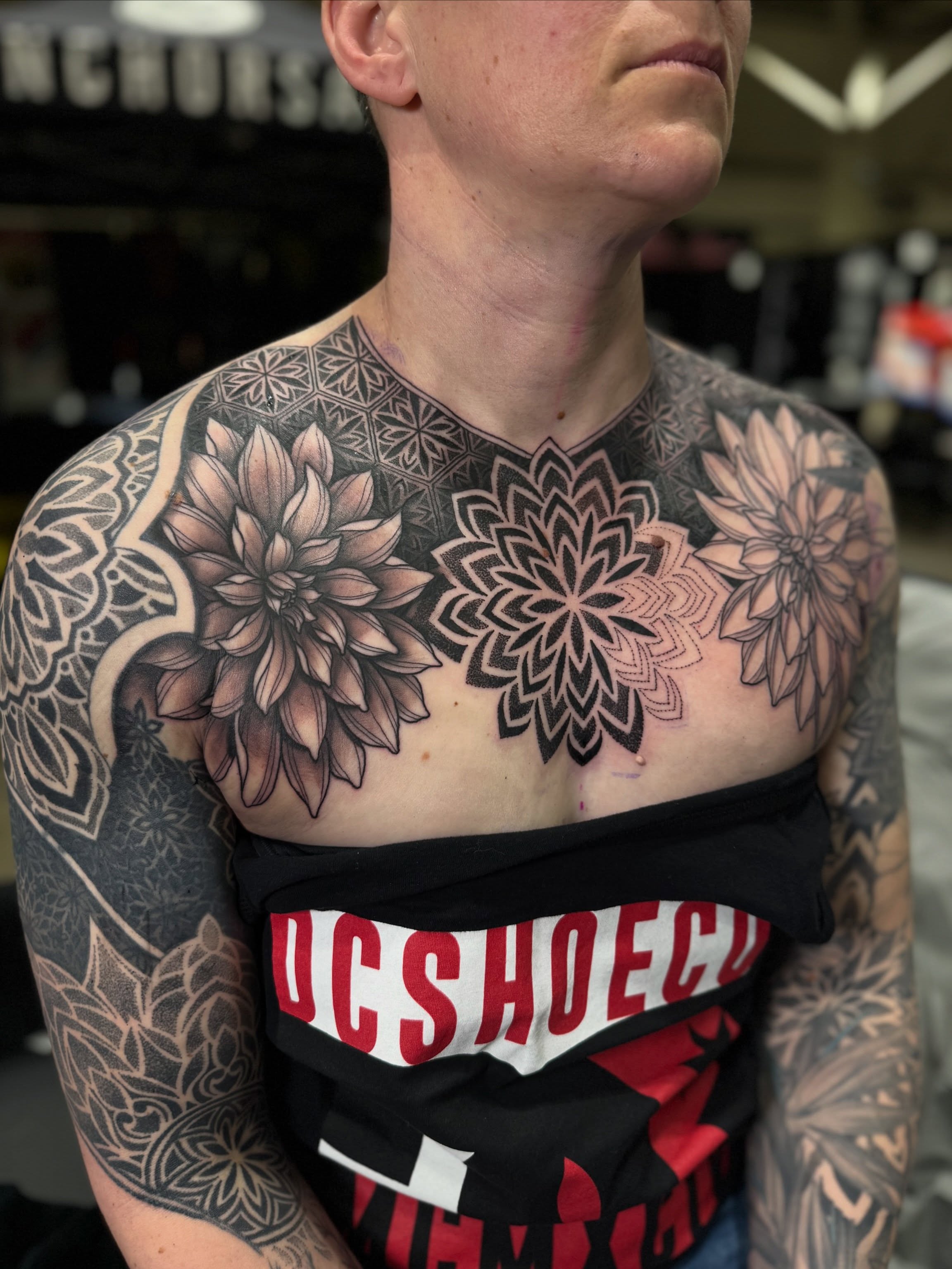 Floral mandala geometric tattoo on the chest by Laure Conzales
