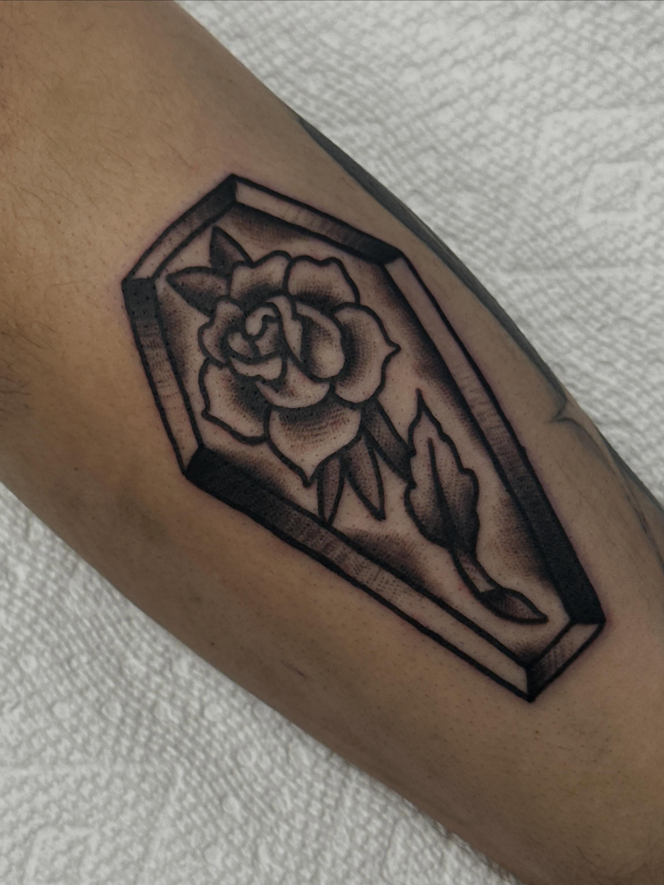 Coffin with rose black and grey tattoo on the forearm by Colbylee Tattoo Norwich