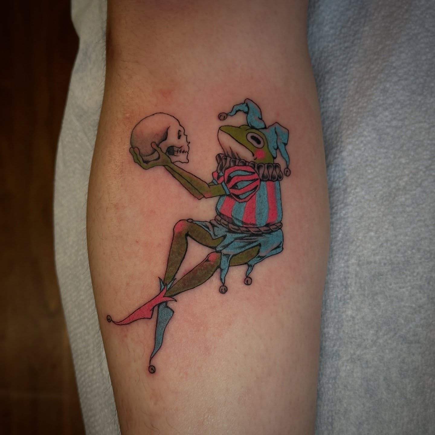 Jester and skull illustrative tattoo on the forearm by Bree Lin