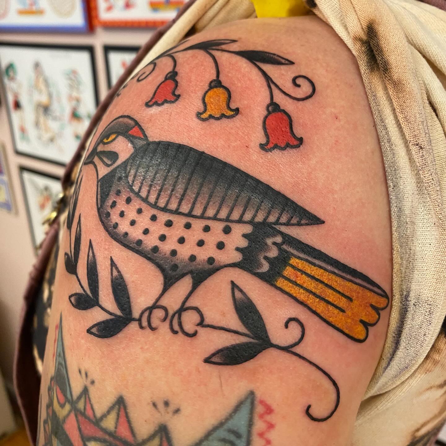Bird with bells American traditional tattoo on the shoulder by Abby Rose Estes