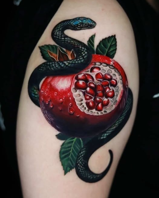 Snake and pomegranate watercolor tattoo on the upper arm by Jules, Arlington, Texas