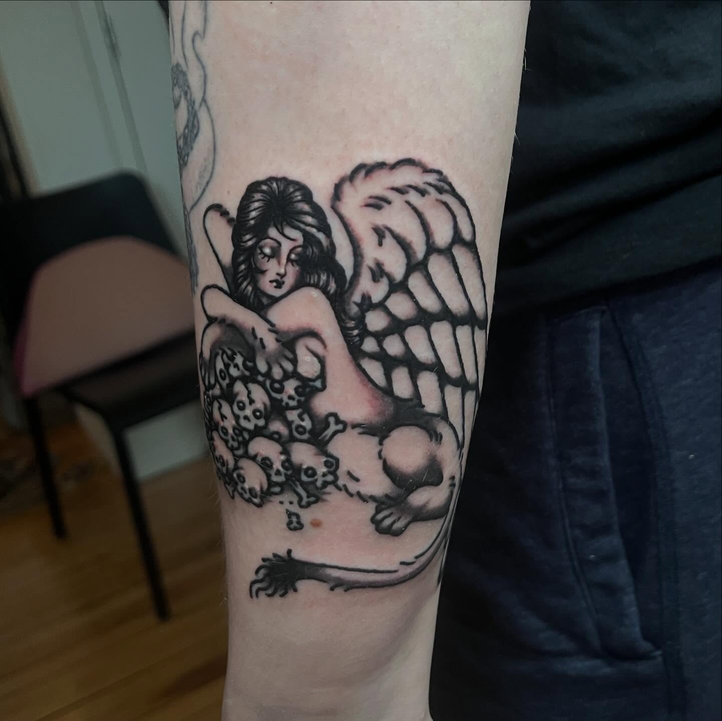 Angel with skulls black and grey tattoo on the forearm by madelynne (maddie) caldwell tattoos
