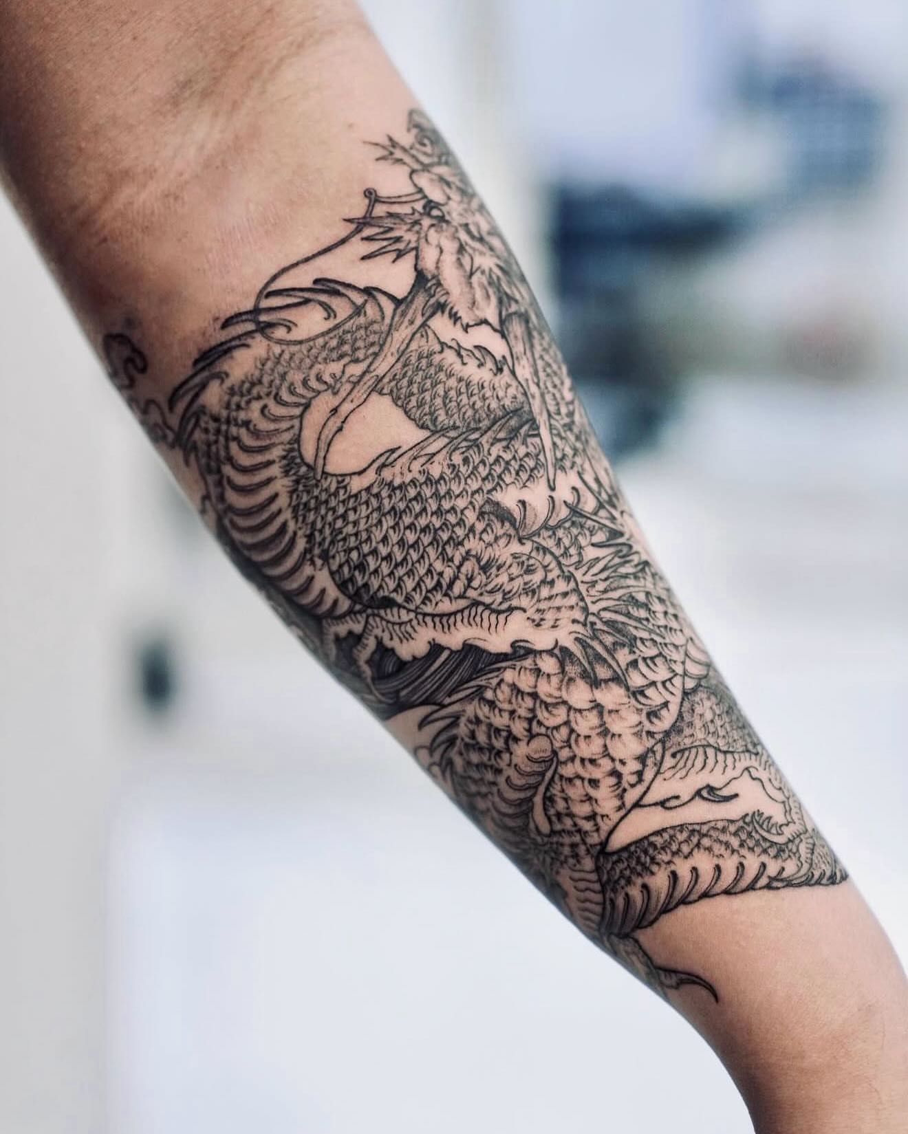 Dragon black and grey tattoo on the forearm by MJ tattooist
