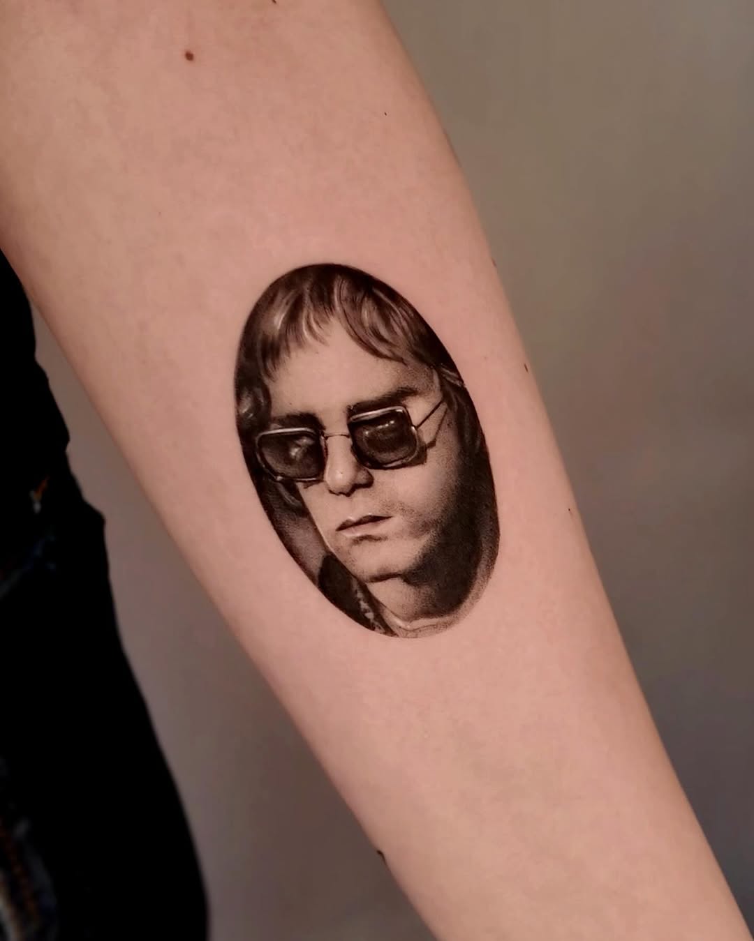 Portrait of Elton John realism tattoo on the forearm by Gabriel