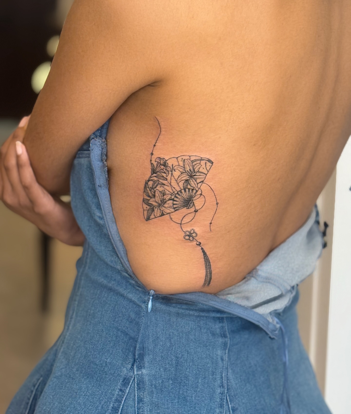 Fan with floral design black and grey tattoo on the back by MJ