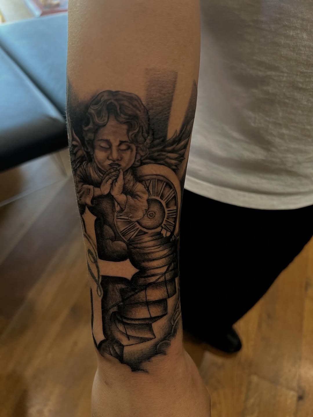 Cherub with clock realism tattoo on the forearm by zion