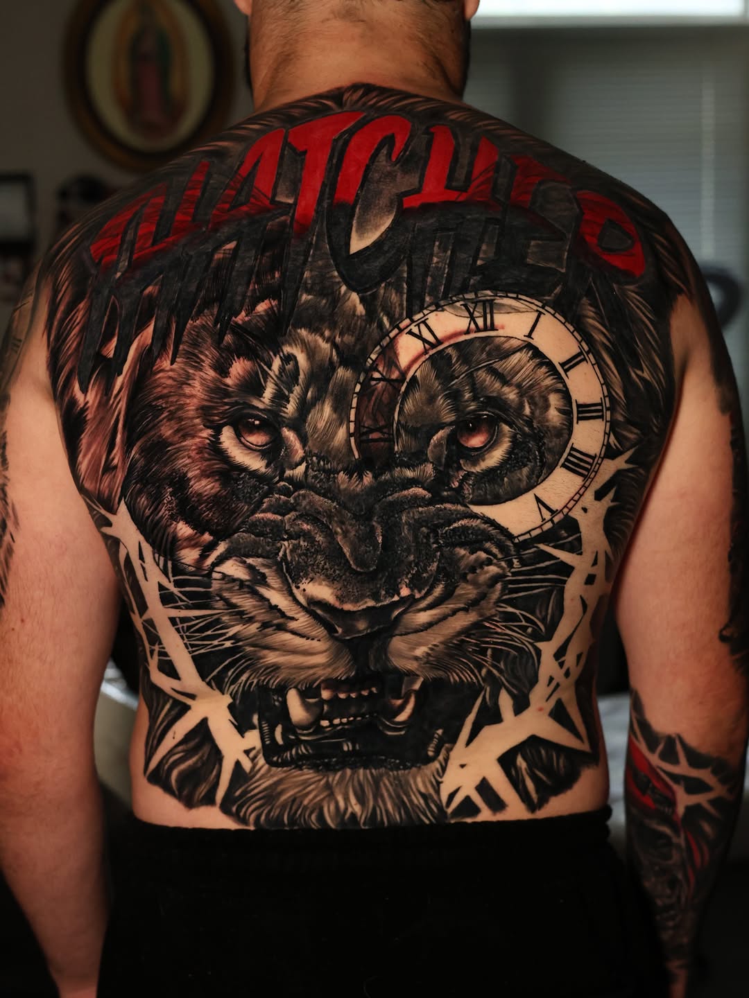Lion head with clock realism tattoo on the back by Insight Ink Tattoo
