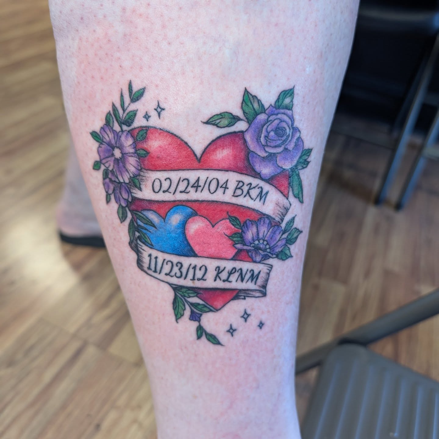 Heart with floral banners American traditional tattoo on the leg by Chad Nuber