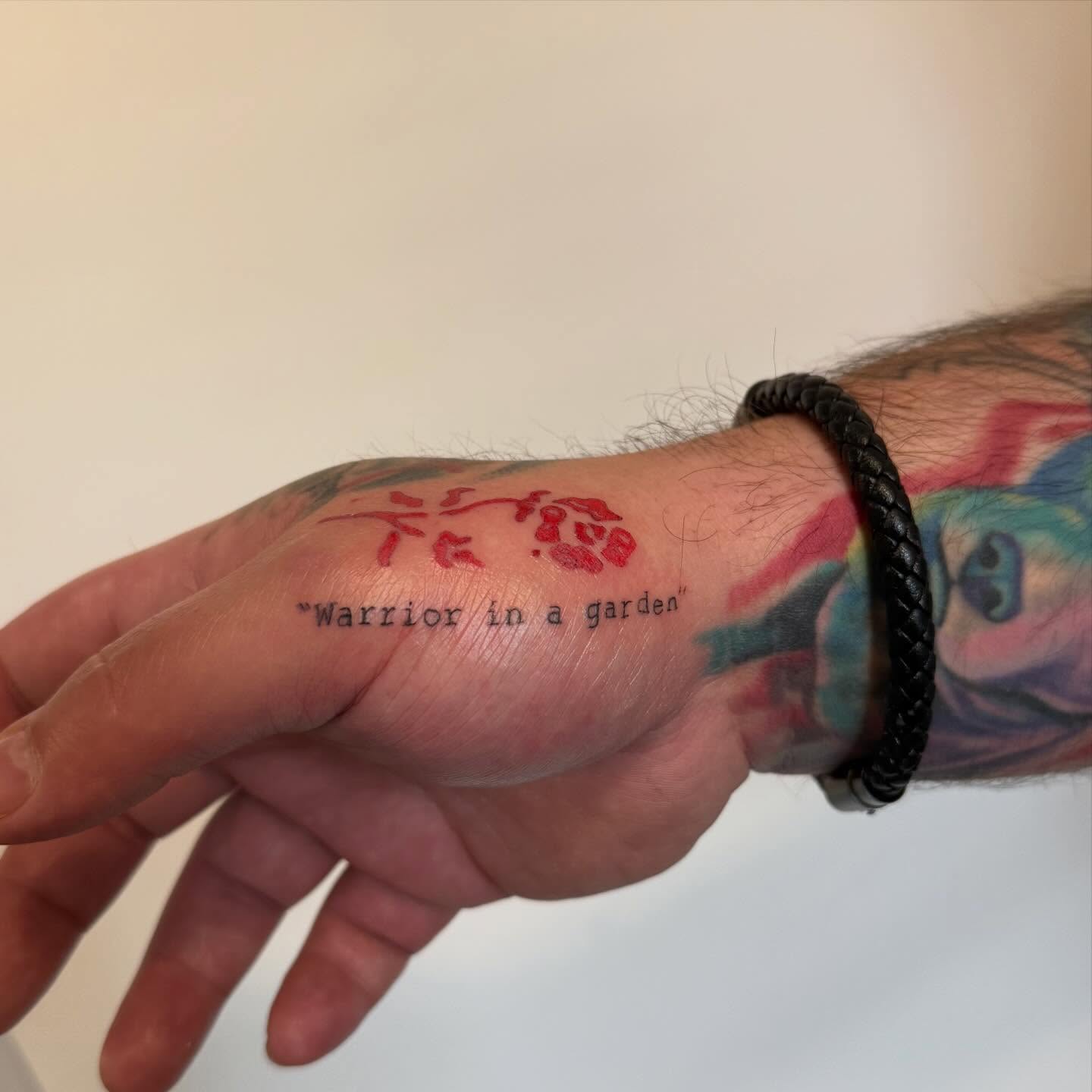 Warrior in a garden lettering script tattoo on the hand by Lexie Decker, Canton, Ohio