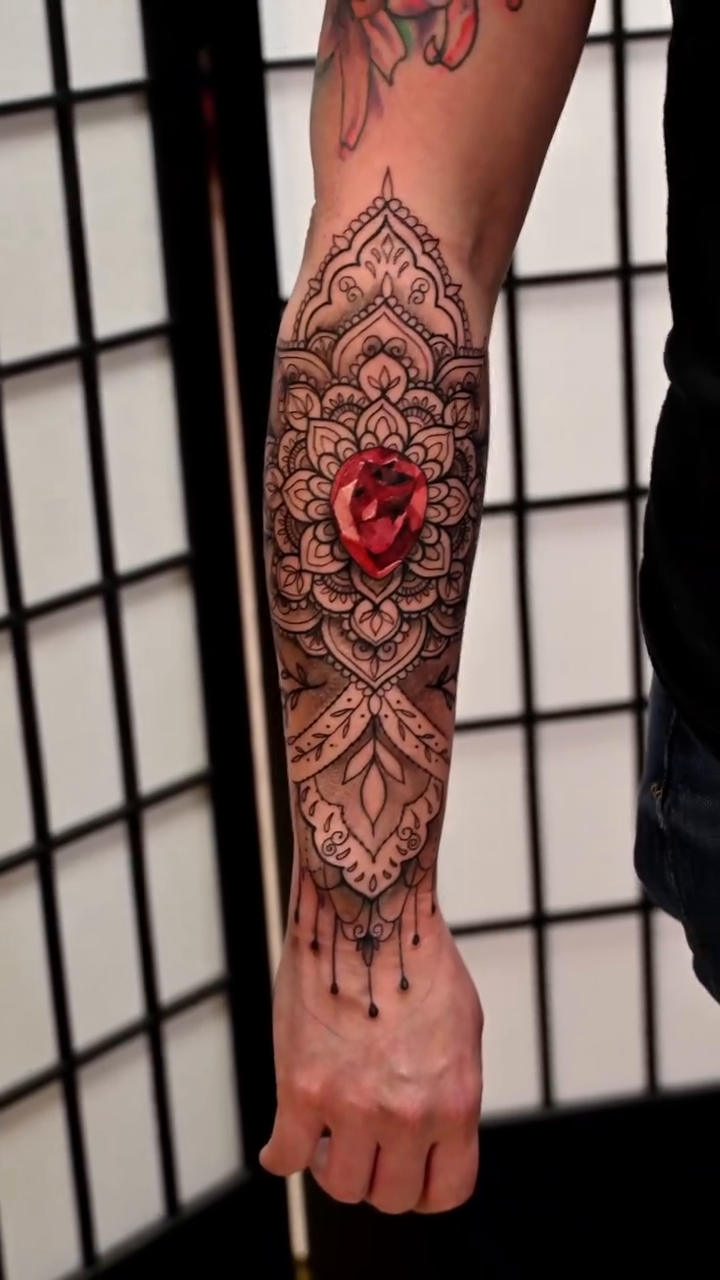Mandala with rose and dangling beads ornamental tattoo on the forearm by Michael ORegan