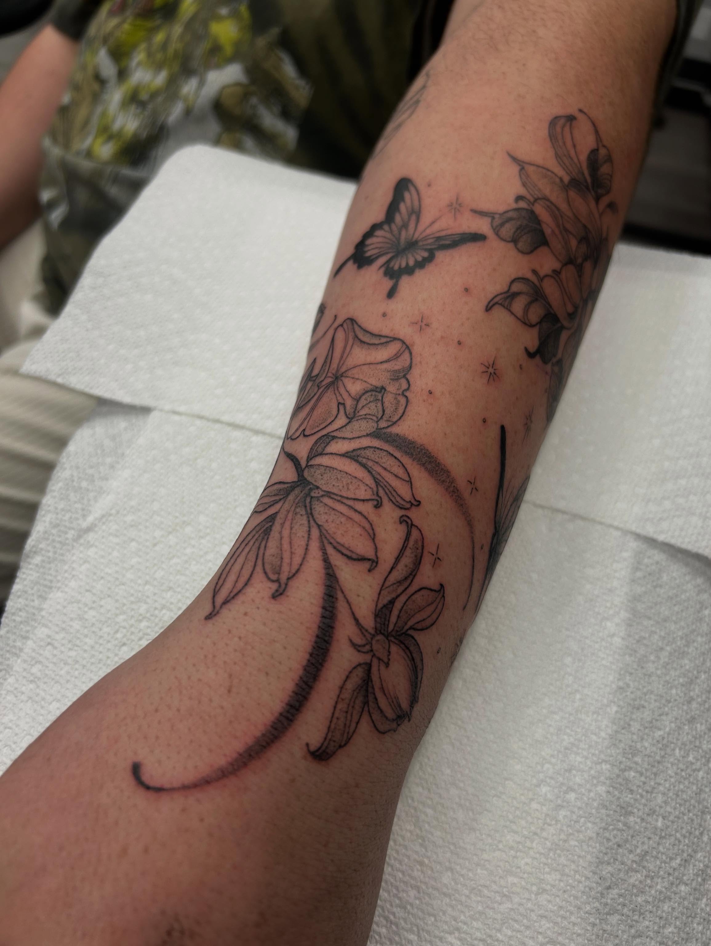 Flowers and butterfly black and grey tattoo on the forearm by Livy baby