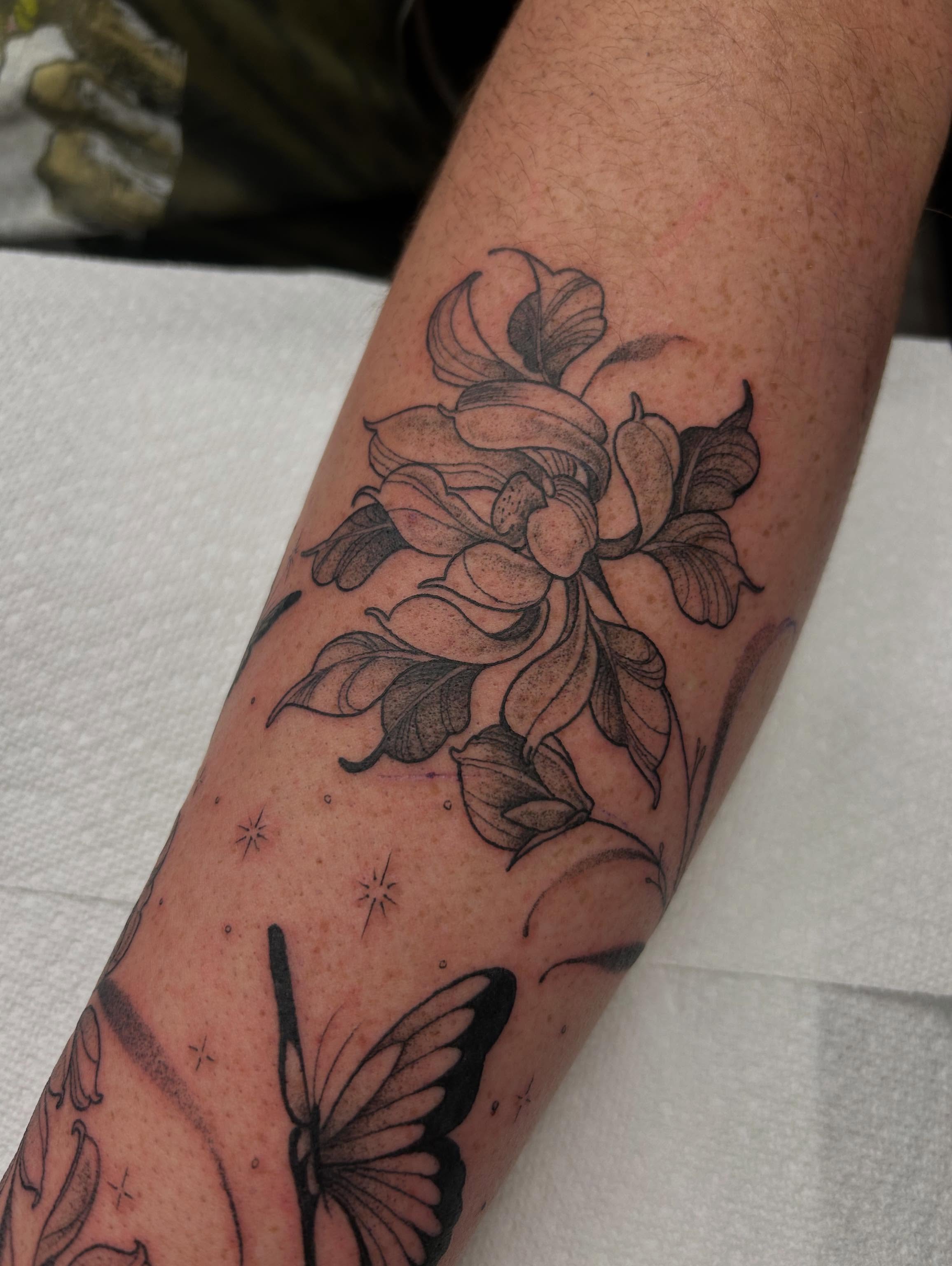 Flower and butterfly black and grey tattoo on the forearm by Livy baby