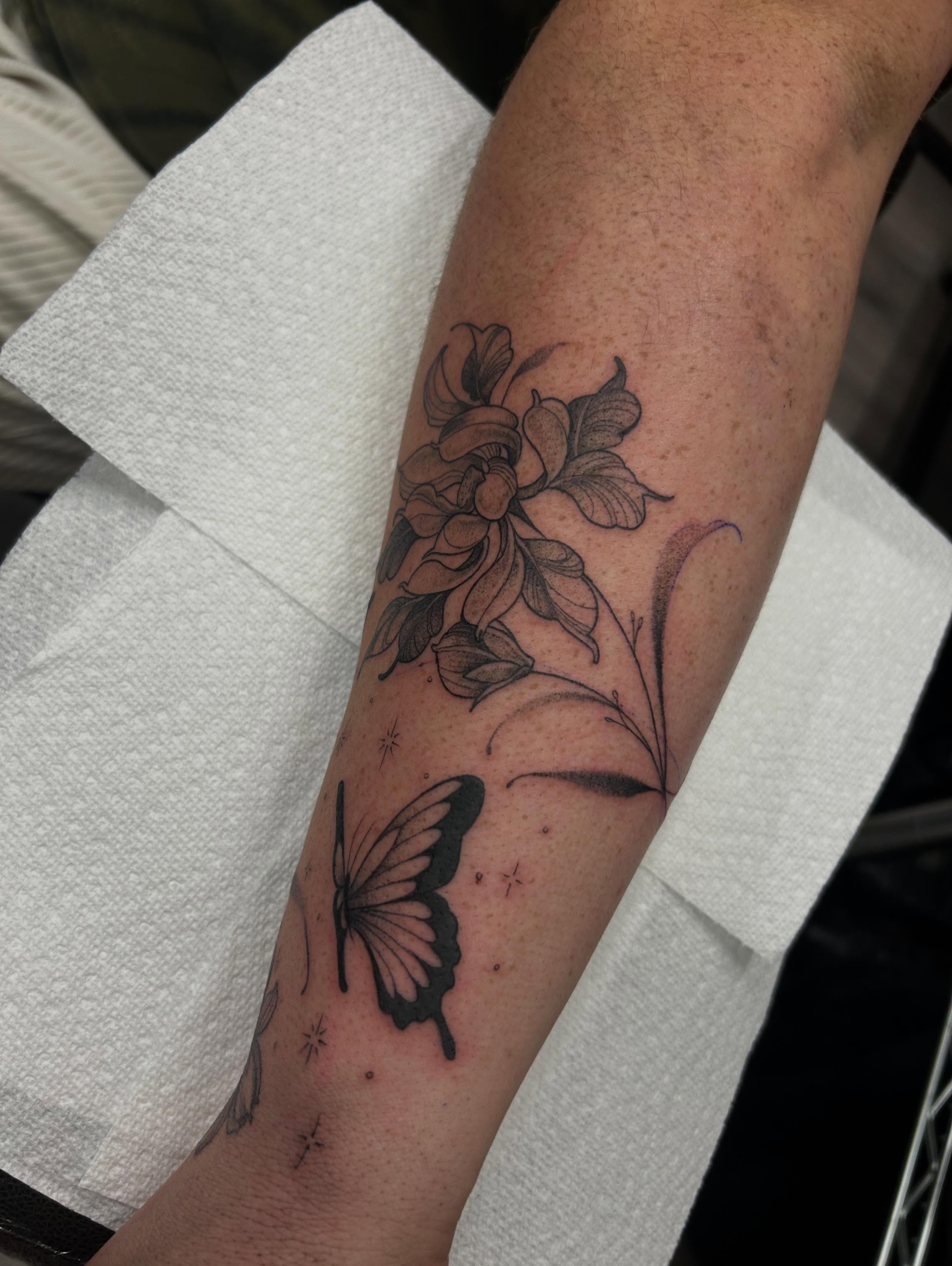 Flower and butterfly black and grey tattoo on the forearm by Livy baby