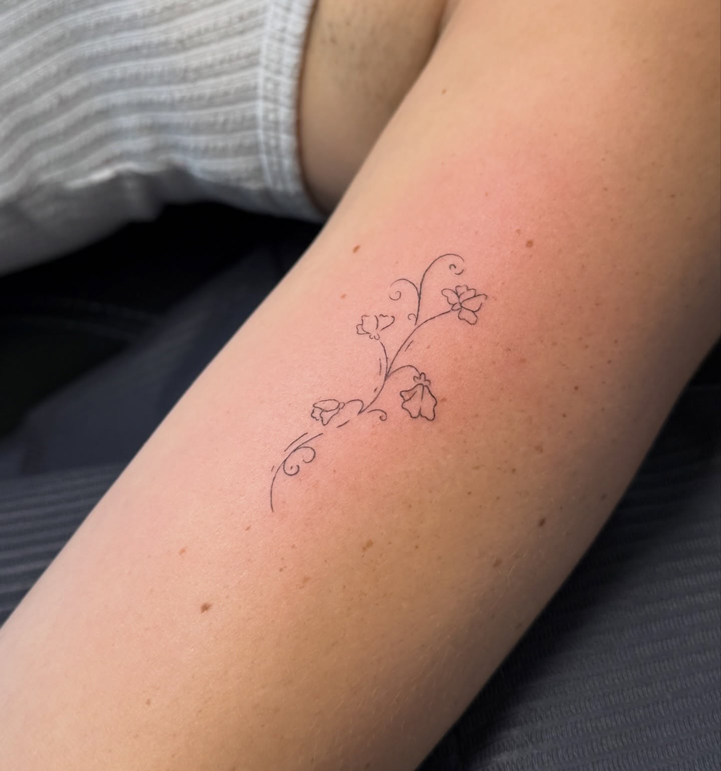 Floral vine fine line tattoo on the forearm by Fine Line Tattoos