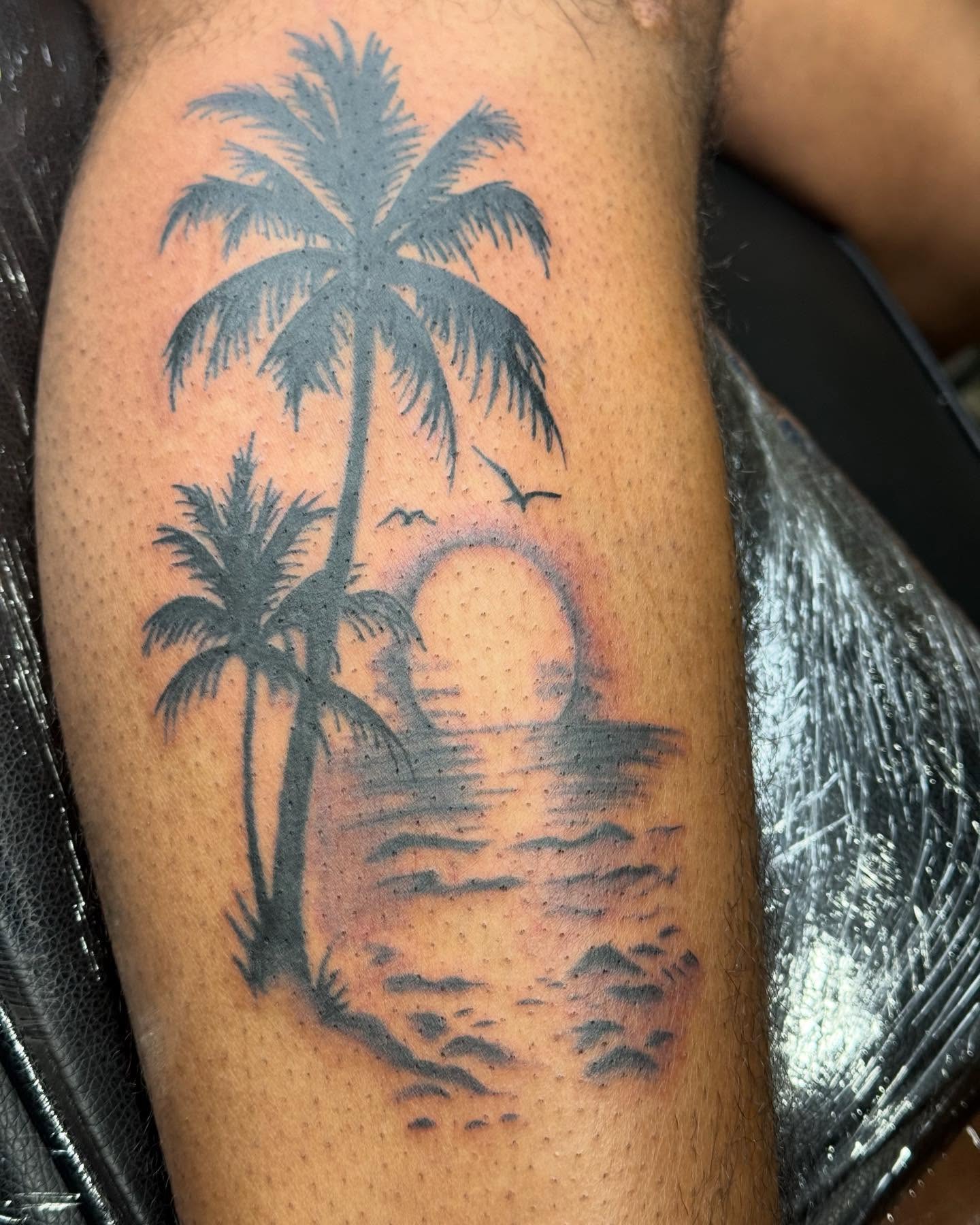 Palm trees and sunset black and grey tattoo on the forearm by Jones Eric