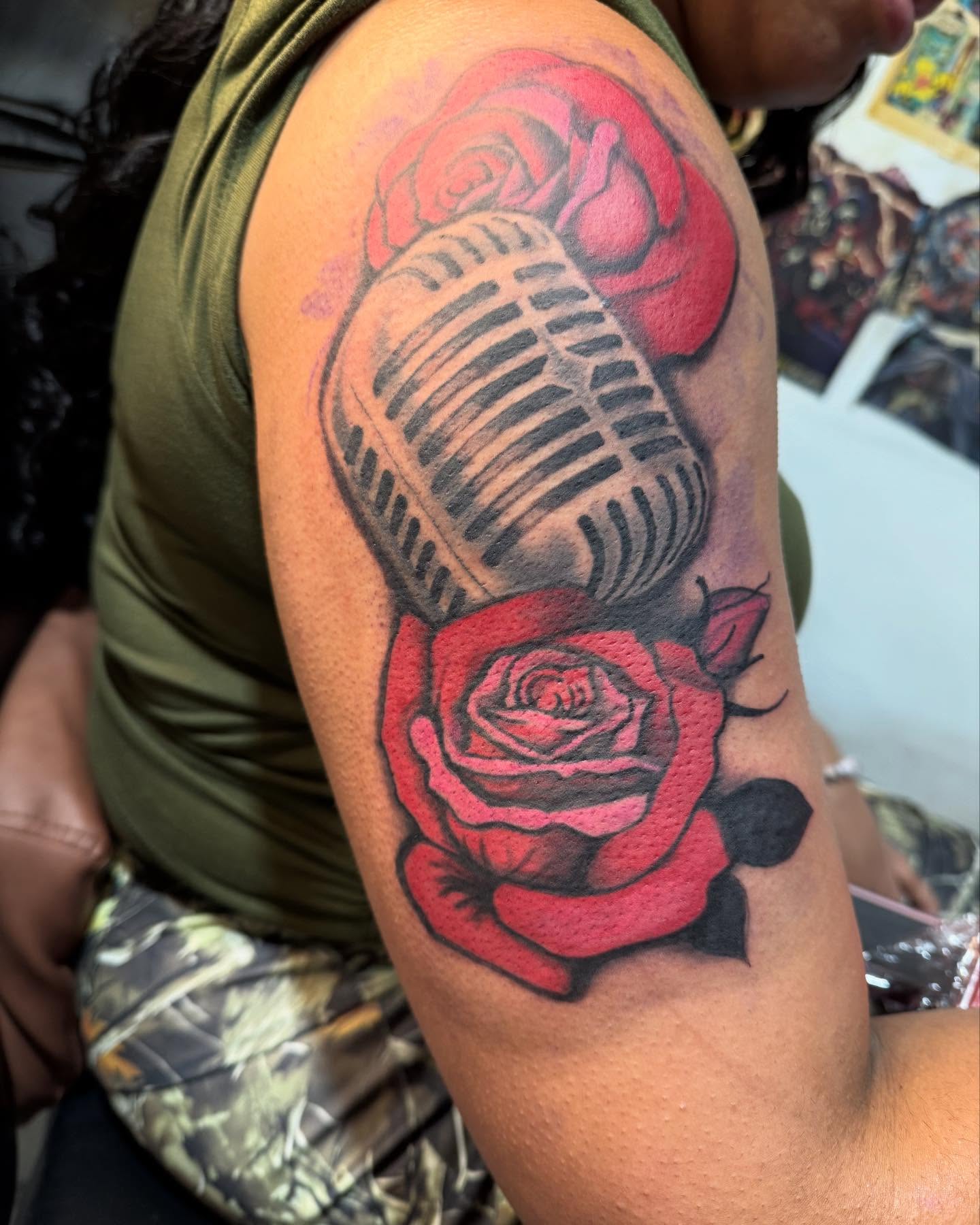 Microphone and roses realism tattoo on the upper arm by Jones Eric