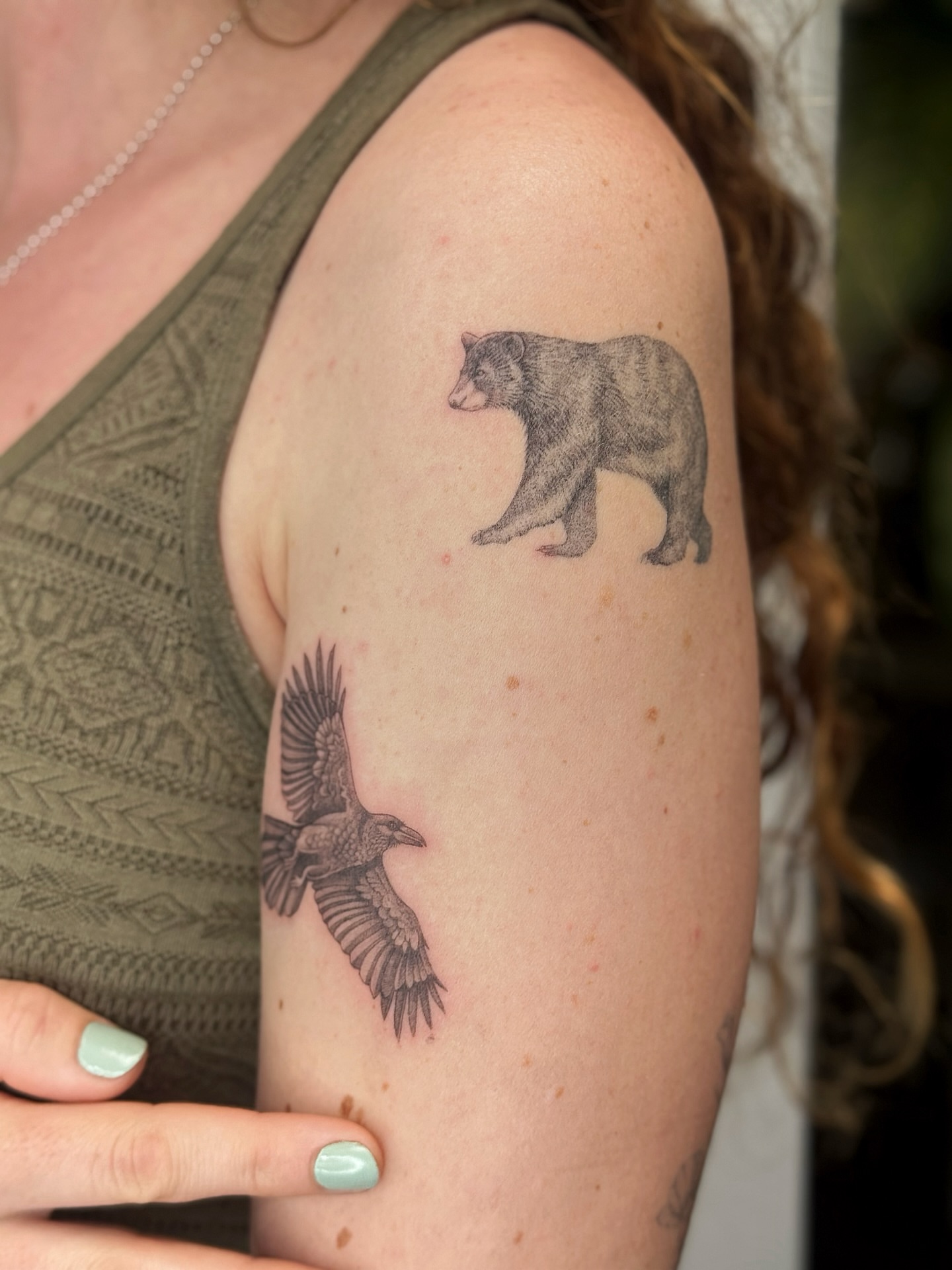 Bear and crow dotwork tattoo on the upper arm by Lea Burkard, Berkeley, California