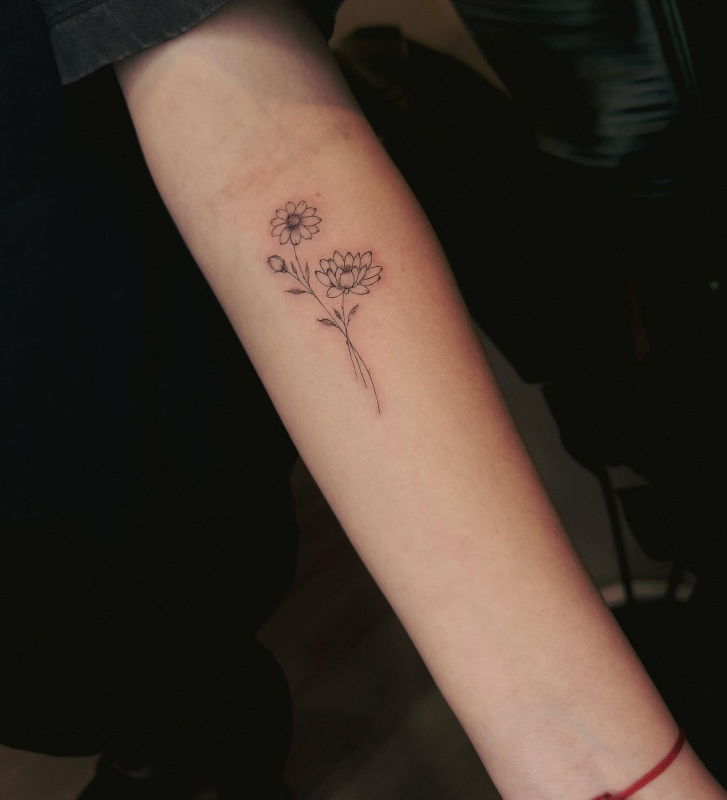 Flowers fine line tattoo on the forearm by Ashley Pilgreen