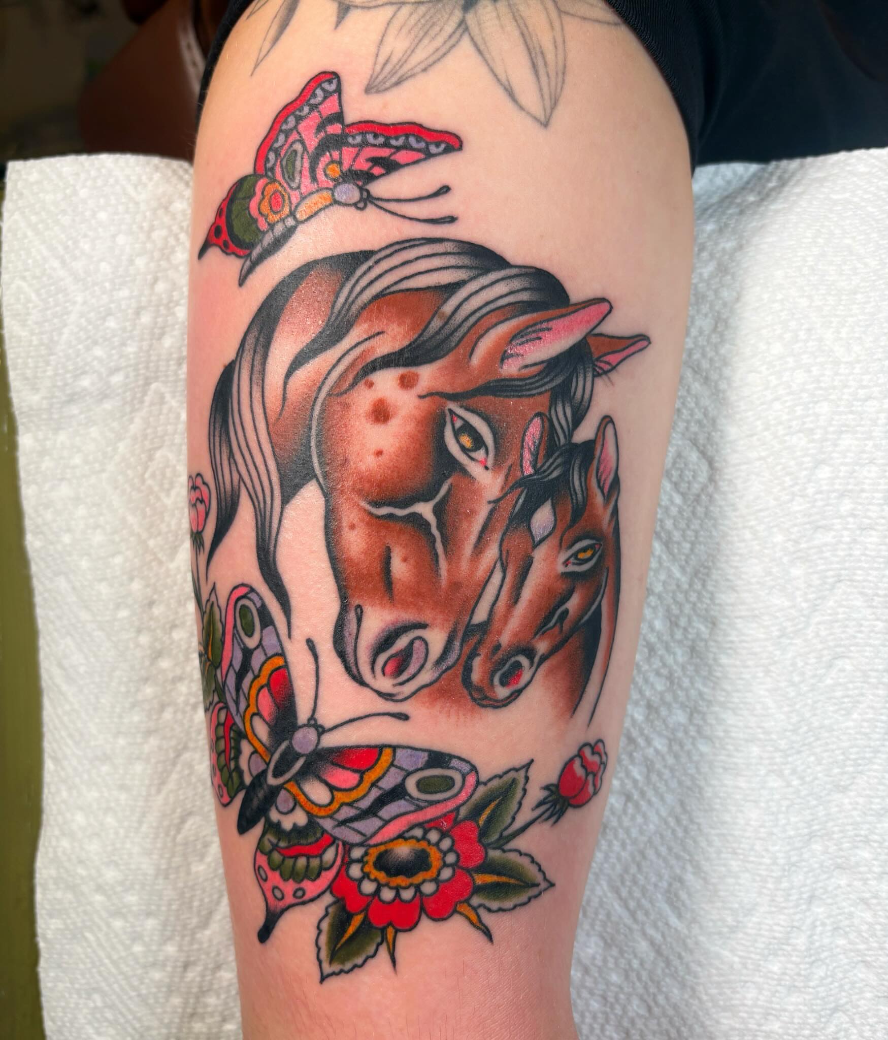 Horse heads and flowers American traditional tattoo on the forearm by Caeli Martin