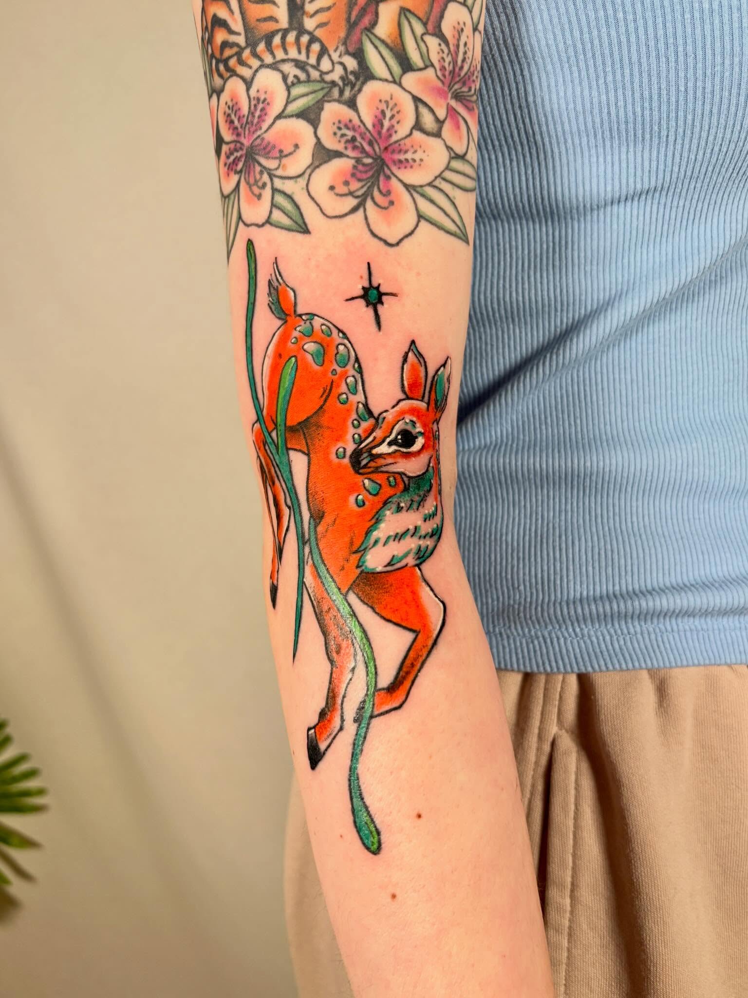 Deer and flowers American traditional tattoo on the forearm by Davie Tattoos
