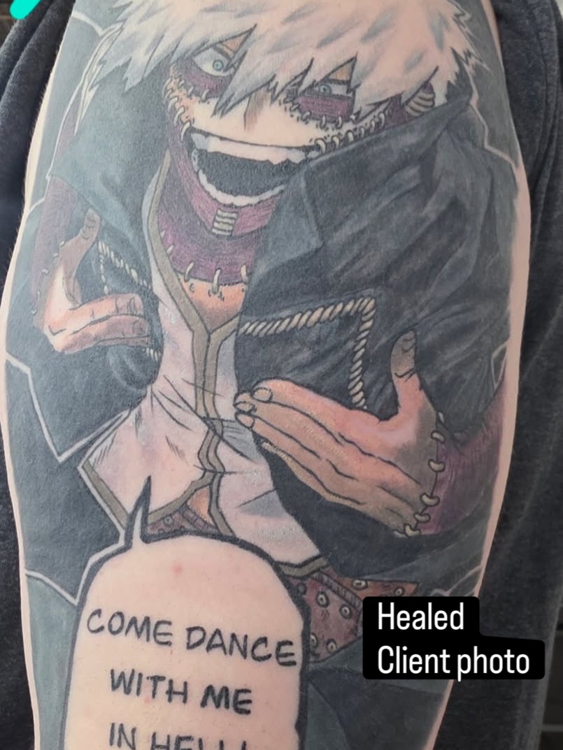 Anime character anime tattoo on the upper arm by Tracci King