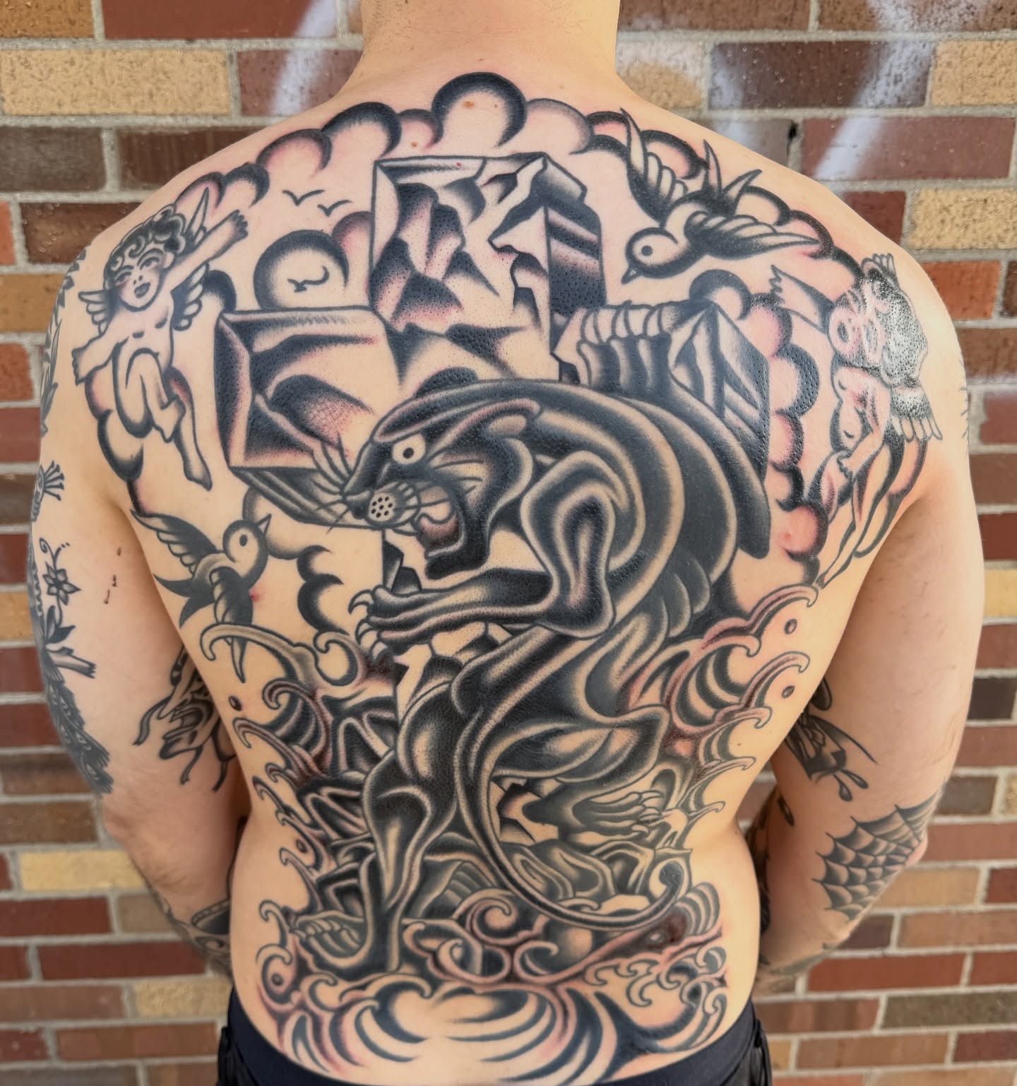 Panther and cherubim American traditional tattoo on the back by Nick Judkins Tattoo