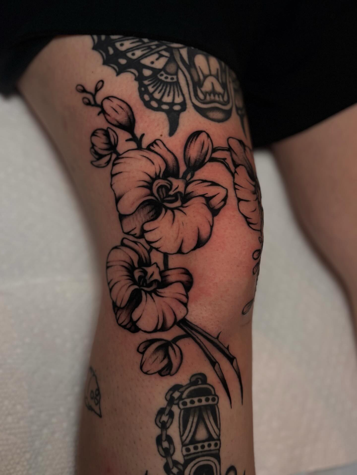 Floral arrangement black and grey tattoo on the thigh by Jesse Smith, Chicago, Illinois