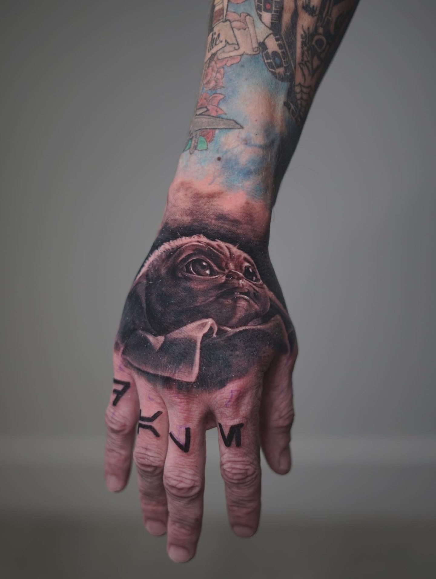 Baby yoda realism tattoo on the hand by Yudel